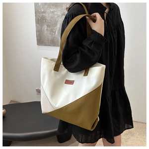 Detailed lifestyle view of a large canvas tote bag in cream and mustard green contrast
