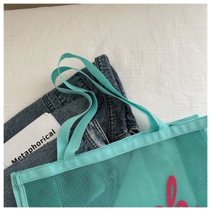 Mint green mesh tote bag with pink artistic lettering for beach or gym use