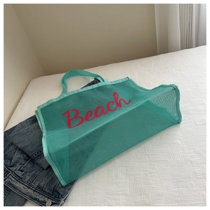 Mint green mesh beach tote bag with red Beach vibes text on white textured bedding