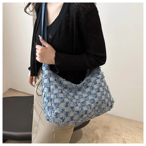 Détail du sac cabas en denim à damier avec texture effilochée porté par un mannequin