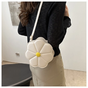 Detail of white 3D floral crossbody bag with yellow center and quilted petal design