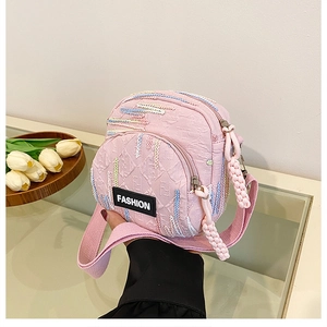 Detail of pink canvas crossbody bag with rainbow embroidery and dual zipper texture