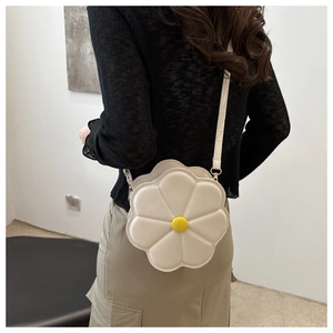 Détail du sac bandoulière en forme de fleur blanche avec texture en cuir matelassé