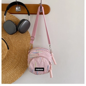 Detail of pink fabric crossbody phone bag featuring FASHION label and colorful embroidery