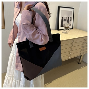 Détail du sac fourre-tout en toile bicolore avec étiquette en cuir et bandoulière grise