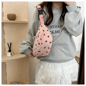 Detailed shot of pink corduroy waist bag with strawberry prints and adjustable buckle strap