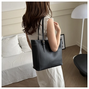 Détail du sac cabas noir avec coutures contrastées blanches et boucle en métal réglable