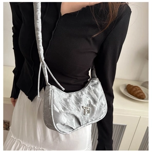 Detailed view of silver hobo bag with pleated texture and metal butterfly buckle