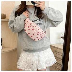 Sac de poitrine en velours côtelé rose avec motif fraise porté par un modèle