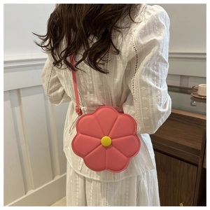 Dettaglio di una borsa a tracolla a fiore rosa indossata di lato, mostra forma e misura