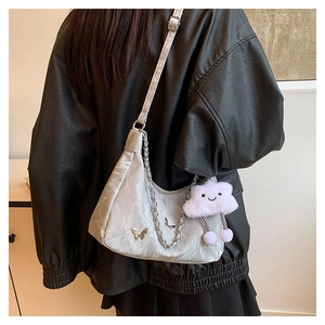 Detail of silver crescent hobo bag with butterfly hardware and plush cloud charm