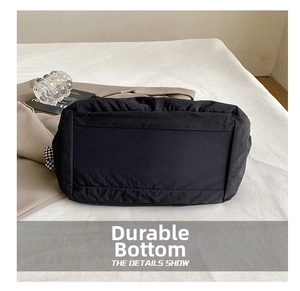 Détail de la structure inférieure résistante à l'usure de ce grand sac fourre-tout noir