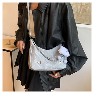Close-up of a grey pleated crescent tote with silver chains and cloud plush charm
