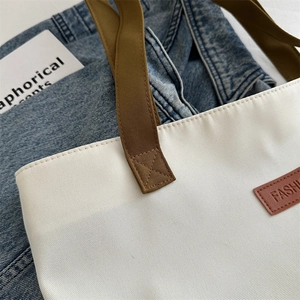 Grand sac fourre-tout minimaliste en toile blanche avec anses marron et patch cuir