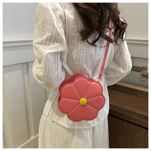 Vue détaillée du sac bandoulière en forme de fleur rose avec cœur jaune sur modèle