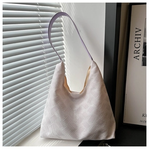 Detail of cream woven tote bag with lavender strap near window lighting