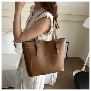 Sac cabas en cuir marron avec coutures blanches contrastées et détail de poche externe