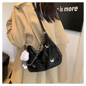 Detail of black crescent shoulder bag with silver butterfly charms and chain strap