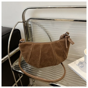 Detail of dark brown matte suede crossbody bag with pleated texture and knotted strap