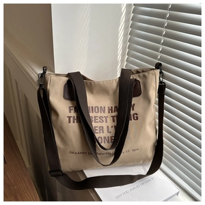 Detailed macro shot of khaki canvas tote bag with adjustable straps on sunny windowsill
