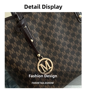 Detail of vintage monogram tote bag with brown leather trim and gold 'M' logo charm