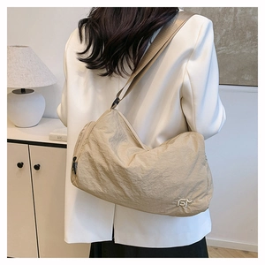 Detail of beige nylon crossbody bag with fashion zipper and comfortable wide shoulder strap