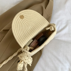 Creamy white woven straw crossbody bag with lace bow and interior makeup storage