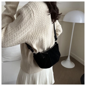 Detailed view of the black pleated crescent bag made of soft suede with metal zipper