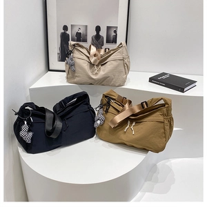 Trois sacs demi-lune en nylon noir, beige et marron avec breloques cœur à damier