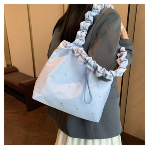 Close-up of light blue pleated tote bag with rhinestone beads and ruffled shoulder strap