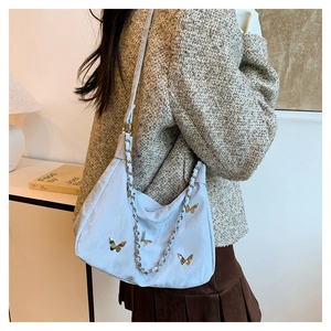 Light blue nylon crescent hobo bag with silver butterfly charms and chain strap