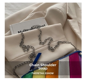 Detail of silver chain strap and iridescent patchwork texture on a small square bag