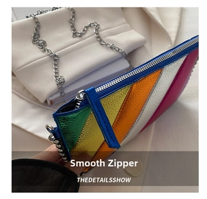 Macro shot of smooth silver metal zipper on rainbow patchwork leather crossbody bag