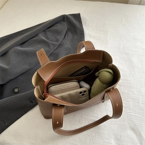 Large brown tote bag showing spacious interior with wallet, umbrella, and accessories