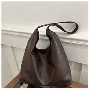 Detail of vintage textured dark brown leather tote bag showing soft material and draping