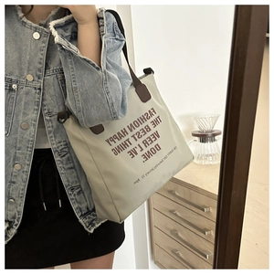 Détail du grand sac cabas en toile beige avec anses marron et imprimé artistique
