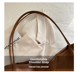 Détail de la bandoulière souple en cuir rond sur un sac cabas marron vintage