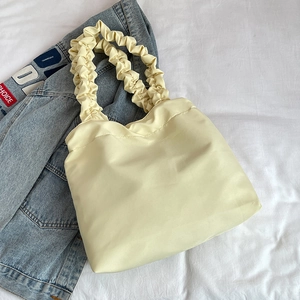 Chic beige pleated tote bag with cloud-style handles and spacious design for summer