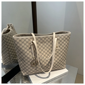 Detail of off-white tote bag with M-pattern print and metallic letter charm pendant