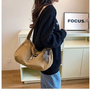 Détail du sac cabas en nylon kaki avec pendentif cœur en damier noir et blanc