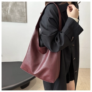 Detailaufnahme der burgunderroten Hobo-Tasche mit hochwertiger Kieseltextur und breitem Gurt