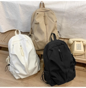 Detail of minimalist nylon backpacks in three colors with woven rope zipper pulls