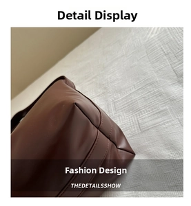 Detailed stitching and texture of the dark brown matte leather base of the shoulder bag