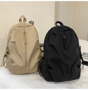 Detail of waterproof nylon backpacks with vertical front zippers and drawstring side pockets