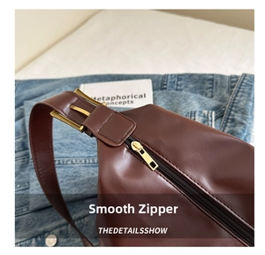Detail of smooth gold metal zipper and premium brown faux leather texture on crossbody bag