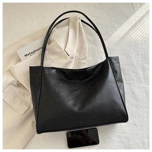 Vue détaillée du grand sac cabas noir en cuir souple montrant la texture et la comparaison de taille