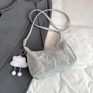 Silver-gray pleated tote bag with plush cloud charm on a minimalist gray background