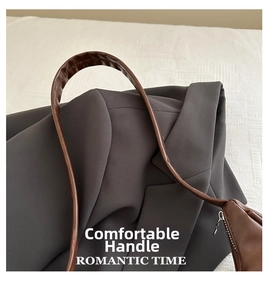 Detail of comfortable brown leather shoulder strap and matte metal zipper on crescent bag
