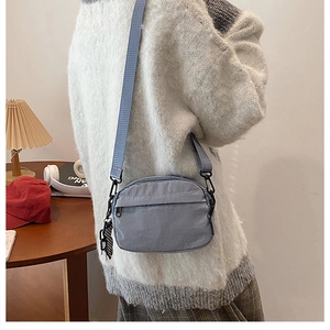 Nylon crossbody phone bag in light blue with adjustable strap and checkered pendant detail