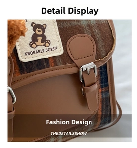 Detail of plaid wool fabric and leather strap with cute bear embroidery on the crossbody bag